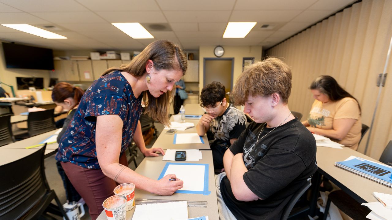 Instructor helps student with an art project in WVC Omak classroom