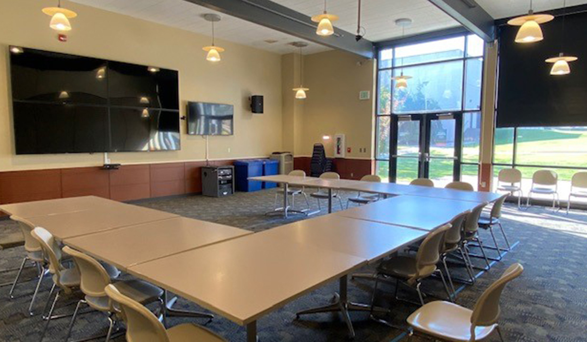 Conference room in Van Tassell Center with boardroom-style seating and a presentation screen.