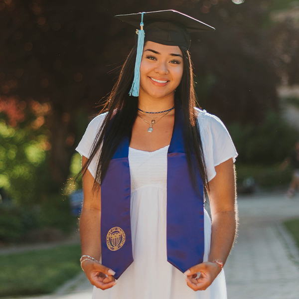 Eden Cazares wearing a graduation cap and purple stole.