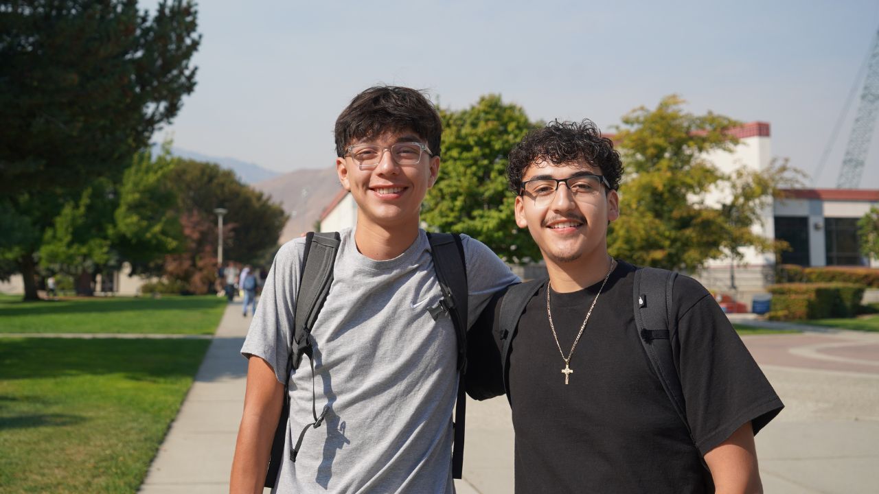 Two students smiling near Wenatchee campus fountain