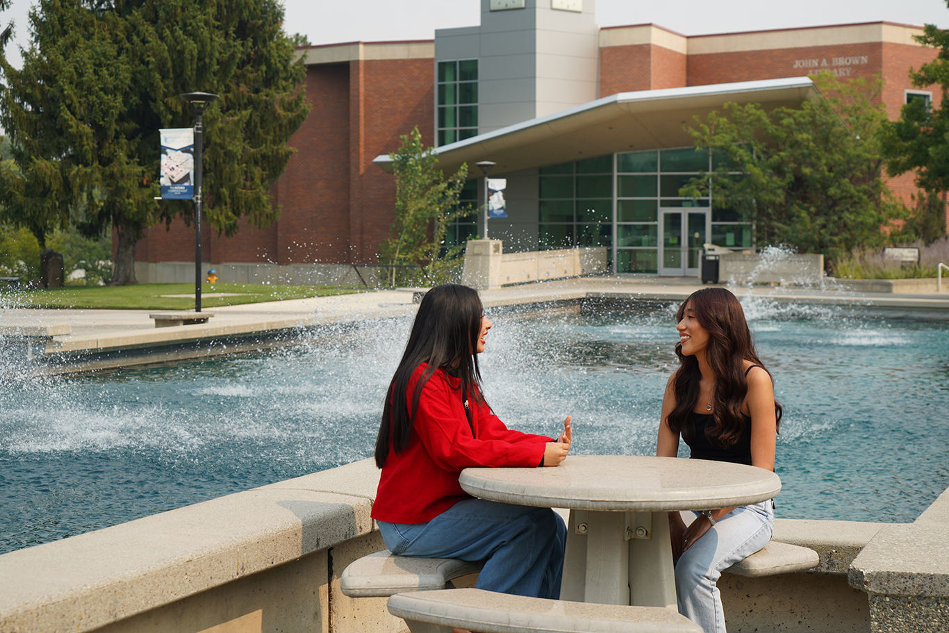 Students sitting by fountain