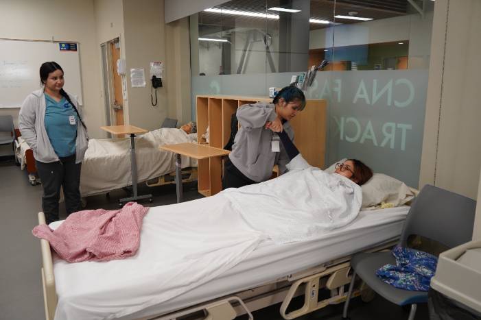 Three students practicing skills in the lab