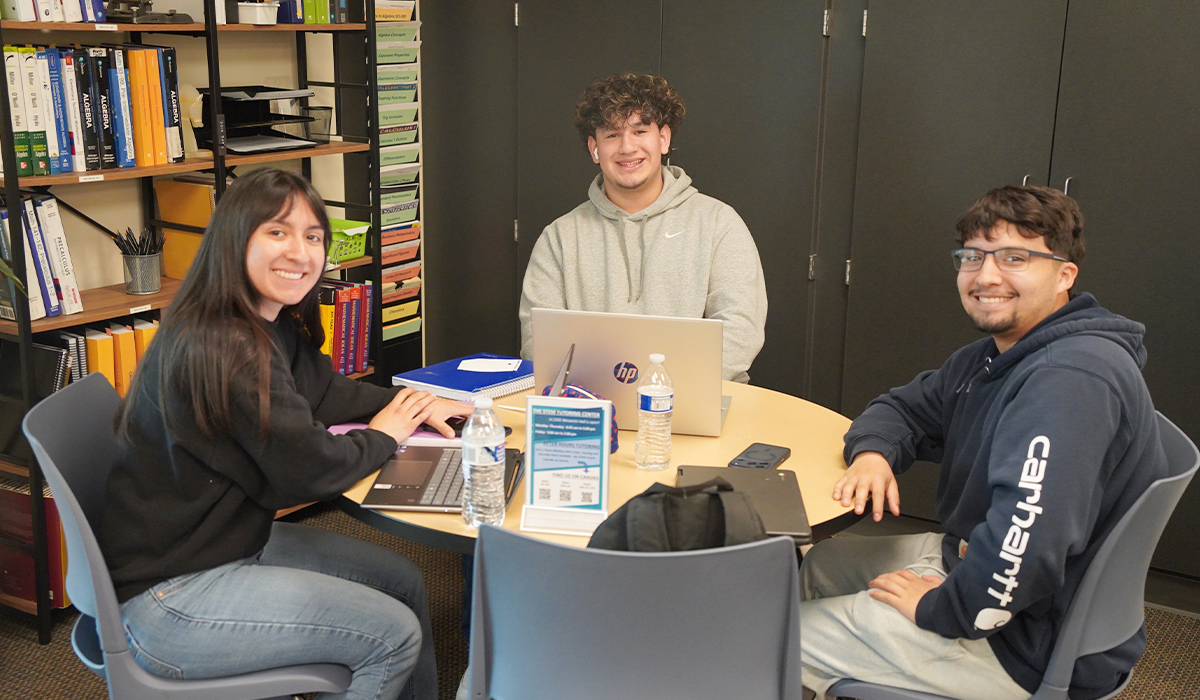 Three students sit at a table in the WVC STEM Center.