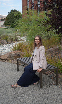 WVC student Karyna Bukovtsova sits on a bench along a gravel pathway.