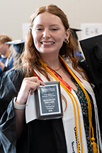 Graduate Shannon Brouse poses with her Outstanding Graduate award