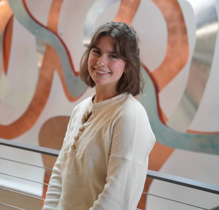 Ava Burk standing in front of Mish ee twie sculpture.