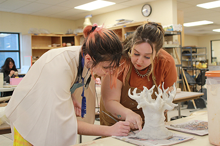 Ceramics Professor Sarah Sprouse helps a student with her ceramics project.
