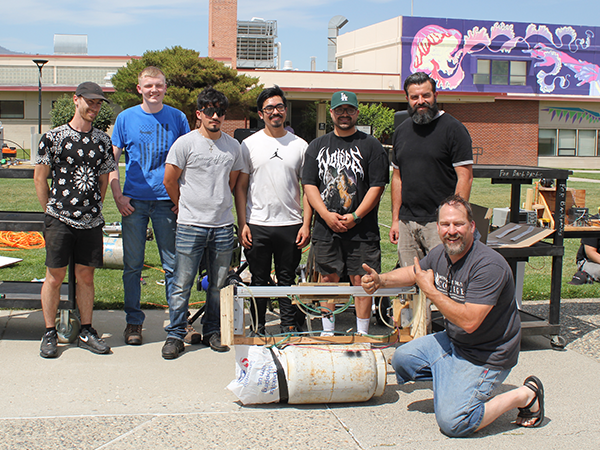 Several Industrial Technology students stand outside with their professor.